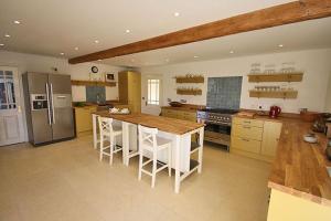 een keuken met een houten tafel en een koelkast bij The Coach House, Wrexham Road in Wrexham