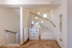a staircase in a house with white walls and white stairs at TAMARI Luxury Villa - Miramare in Pefkohori