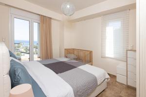 a bedroom with a bed with a view of the ocean at TAMARI Luxury Villa - Miramare in Pefkohori +13 photos