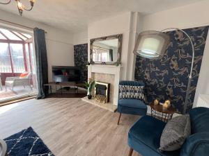 a living room with a blue couch and a mirror at Harrowby Home in Lincolnshire