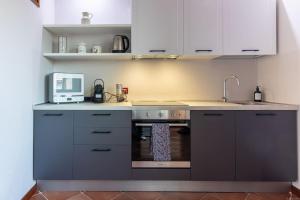 una cucina con lavandino e forno a microonde di [Tre Gradini - Posizione ottima] a Ferrara