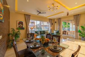 a dining room with a table and chairs and a living room at Ekostay Gold - SUCASA VILLA - Games Room - Private Pool in Lonavala
