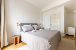 a white bedroom with a large bed and a lamp at Stylish Apartments in CPH City in Copenhagen +168 photos