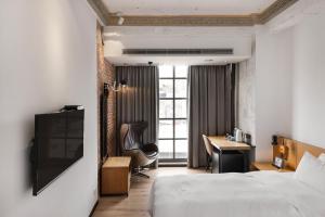 Pokój hotelowy z łóżkiem i biurkiem w obiekcie BlueSky Hotel w mieście Taizhong