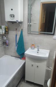a bathroom with a sink and a mirror and a tub at W Barlinku na rynku in Barlinek