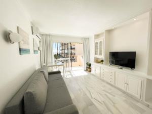 salon z kanapą i telewizorem z płaskim ekranem w obiekcie Erisa Terral Apartments w mieście Torremolinos