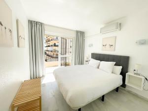 sypialnia z dużym białym łóżkiem i oknem w obiekcie Erisa Terral Apartments w mieście Torremolinos