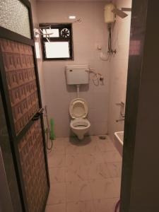 a small bathroom with a toilet and a window at Hotel Seaview in Murud