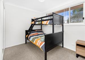 Lakeside Retreat في Lake Illawarra: سرير بطابقين أسود في غرفة مع نافذة