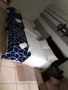 a bed with a blue and white comforter and pillows at Charis Guesthouse in Hartswater