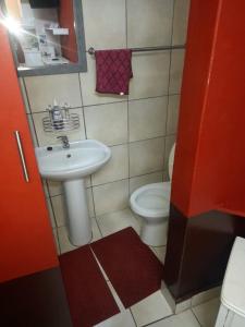 a small bathroom with a sink and a toilet at Charis Guesthouse in Hartswater
