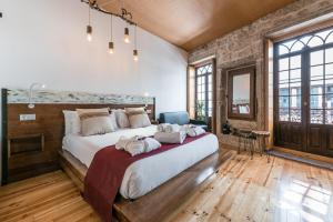 a bedroom with a large bed with towels on it at GuestReady - CastleRock Pub & Hotel in Porto +19 photos