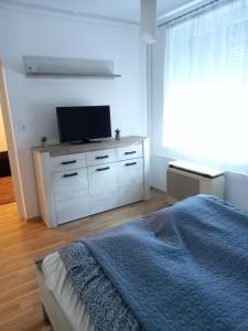 a bedroom with a bed and a flat screen tv at Zsóka Apartman in Miskolc