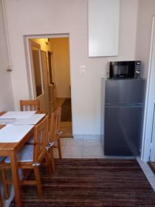 a kitchen with a table and a refrigerator at Zsóka Apartman in Miskolc