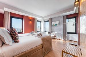 a bedroom with a large bed with red walls and windows at GuestReady - Portfolio GuestHouse in Porto
