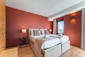 two beds in a room with red walls at GuestReady - Portfolio GuestHouse in Porto