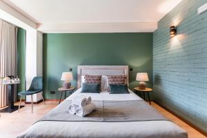 a bedroom with a large bed with a green wall at GuestReady - Portfolio GuestHouse in Porto