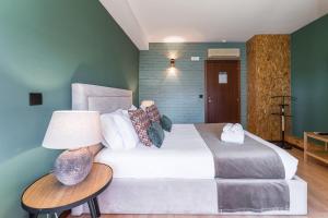 a bedroom with a large bed and a table with a lamp at GuestReady - Portfolio GuestHouse in Porto