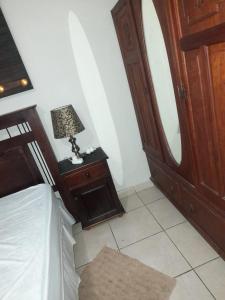 a bedroom with a bed and a dresser and a lamp at Charis Guesthouse in Hartswater