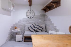 een woonkamer met een bank en een klok aan de muur bij [Ferrara Centro - Il rifugio di Debe] in Ferrara
