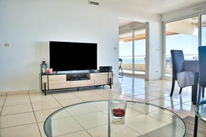 a living room with a tv and a glass table at LE PALAIS dETE T4 6-8 115m2 grand standing garage carplug in Canet-en-Roussillon