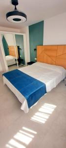 1 dormitorio grande con 1 cama grande con sábanas azules en LOS PISOS DE CONCHA, en Benidorm