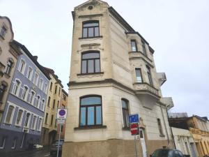 a tall white building with windows on a street at Work & Stay Apartment in Stolberg bei Aachen in Stolberg