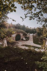 un camino de piedra con un puente en un jardín en Mobbiton Mostar - unique underground stay, en Mostar