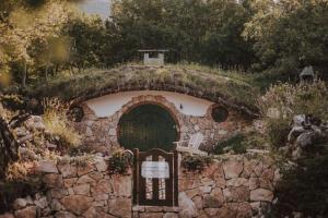 a stone building with a cross on top of it at Mobbiton Mostar - Magical Underground Retreat in Mostar +54 photos