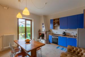 uma cozinha com armários azuis e uma mesa de madeira num quarto em Charme Montecatini Villa em Pieve a Nievole