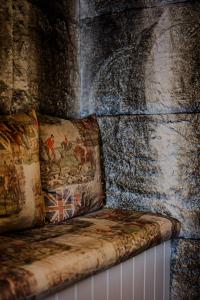 a couch against a stone wall with a waterfall at The White Hart Hotel in Hingham