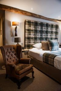 a hotel room with a bed and a chair and a chair at The White Hart Hotel in Hingham