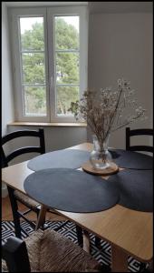 - une table à manger avec un vase de fleurs dans l'établissement Superbe t2 lumineux refait à neuf, à Dinard