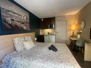 a bedroom with a bed and a kitchen with a table at STUDIO PRADO PLAGE PISCINE TERRASSE in Marseille