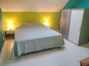 1 dormitorio con cama y pared verde en GITE DE GROUPE - 14 PERSONNES, en Faye-dʼAnjou