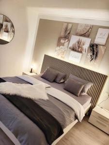 a bedroom with a large bed with pictures on the wall at Moderne Ferienwohnung in Friedrichshafen