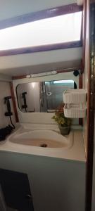 ein Bad mit einem Waschbecken und einem Spiegel in der Unterkunft Juangie Home in Valencia