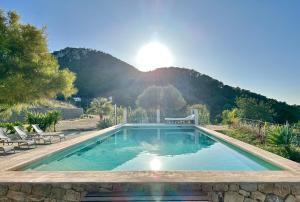 a swimming pool with a mountain in the background at Villa Mimosa in Sant Josep de Sa Talaia