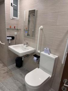 a bathroom with a white toilet and a sink at La Bella Guesthouse in St. Julianʼs