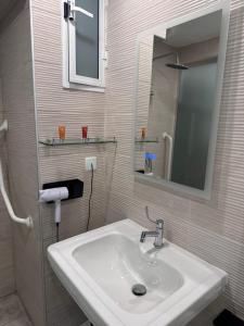 a bathroom with a sink and a mirror at La Bella Guesthouse in St. Julianʼs
