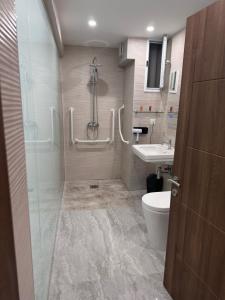a bathroom with a shower and a toilet and a sink at La Bella Guesthouse in St. Julianʼs