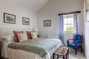 een slaapkamer met een bed, een stoel en een raam bij The Coach House, Wrexham Road in Wrexham