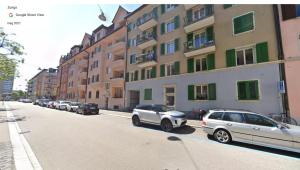 a street with cars parked in front of a building at H2 with 3,5 rooms, 2BR, living room and kitchen, central and quite in Zürich