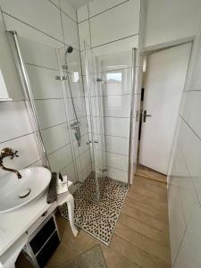 ein Bad mit einer Dusche und einem Waschbecken in der Unterkunft Ferienbungalow Muranko am Kiessee in Krugsdorf