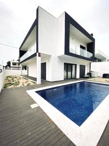 a house with a swimming pool in front of it at Luxury villa surrounded by nature and beach in Amora