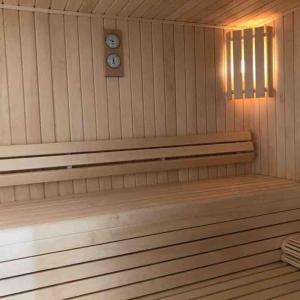 a bench in a sauna with a clock on the wall at Chalet le Villarais1 sauna billard in Villard-Reculas