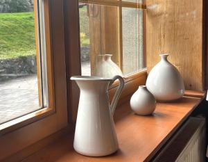 three white vases sitting on a window sill at Ferienwohnung Seeblick Nr 2 5-Zimmerwohnung - Feldberg Bärental in Feldberg