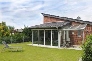 a extension to a brick house with a conservatory at Ferienapartment Birkenhain in Wettringen