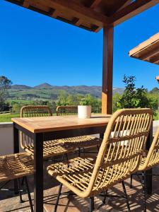 una mesa de madera y sillas en un patio en Terradeva Apartamentos, en Colombres