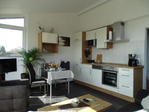 cocina y sala de estar con mesa. en Ferienapartment Birkenhain en Wettringen